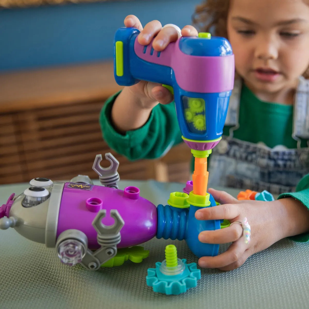 A child using a learning resources, design and drill set to build a robot! Build motor skills and creativity!