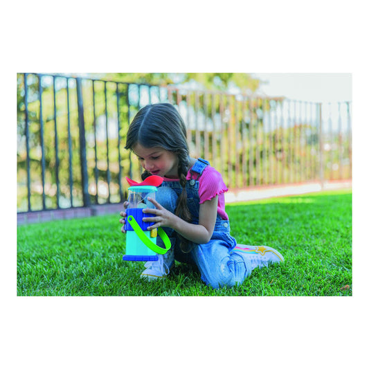 A child exploring the outdoors with Educationsl Insights GeoSafari Jr. Rocknoculars, peering through the magnifier while kneeling on the grass.