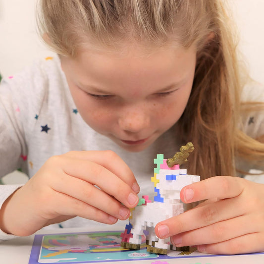 A girl assembling a colorful Plus-Plus unicorn model, carefully connecting interlocking pieces to bring the magical design to life.