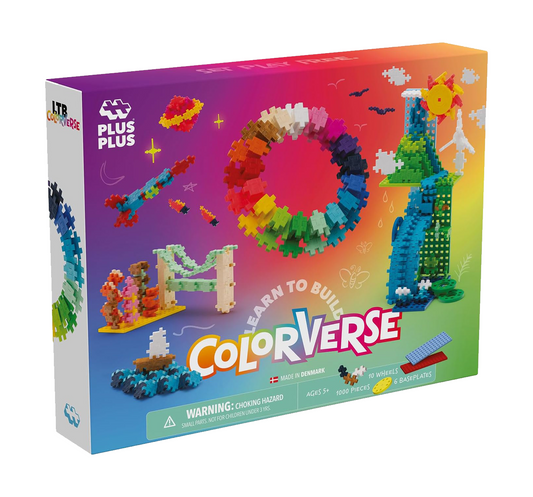 A colourful assortment of Plus-Plus pieces arranged in a vibrant pattern, featuring interlocking shapes in shades of blue, red, yellow, and green.