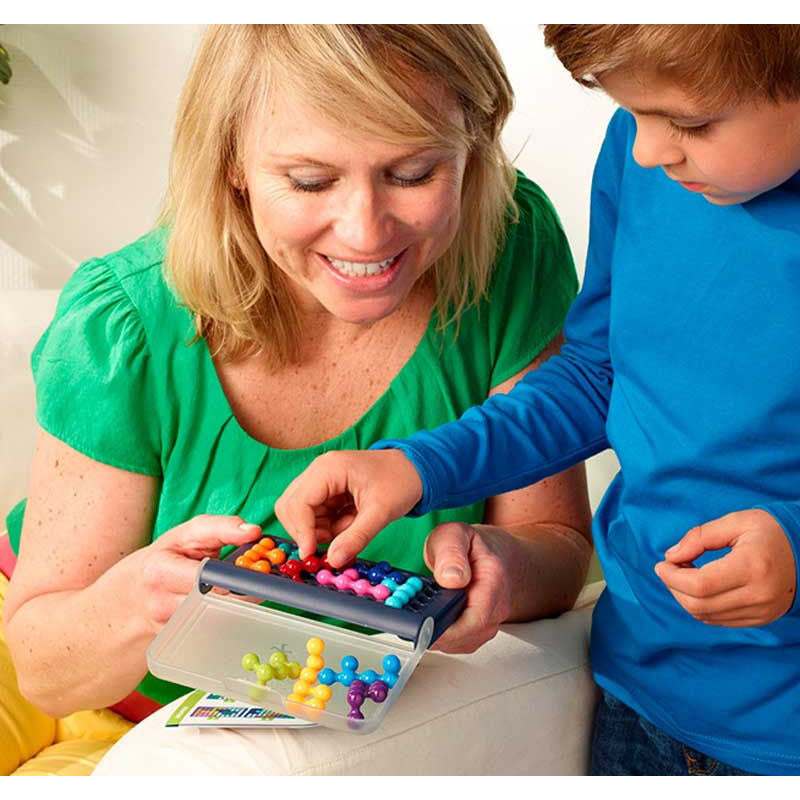 "A mother and child playing with SmartGames IQ Fit, carefully placing colorful 3D puzzle pieces onto the compact game board, engaging in logic-based problem-solving together.