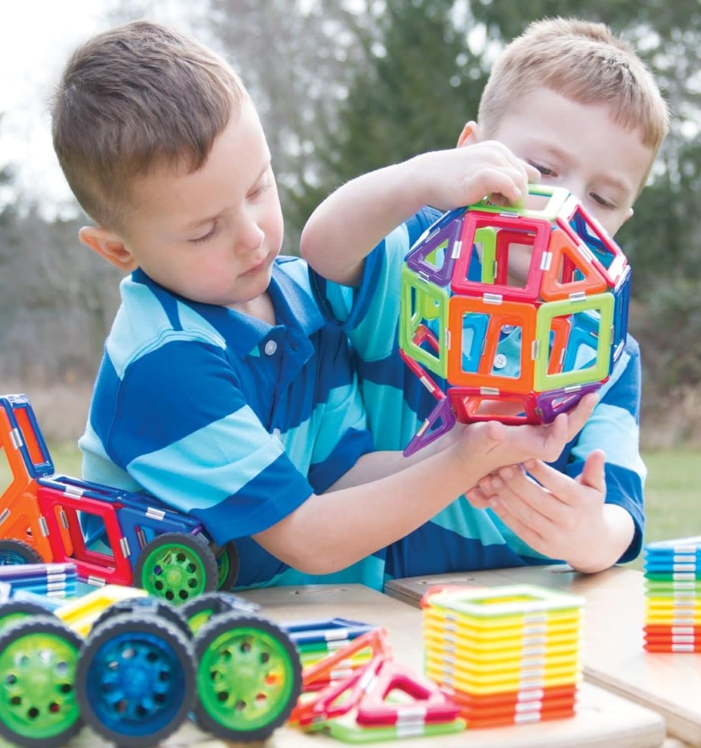 "Children engaging with GeoSmart RoboRacer magnetic tiles, assembling colorful geometric pieces to build a motorized vehicle, fostering STEM learning and hands-on creativity.
