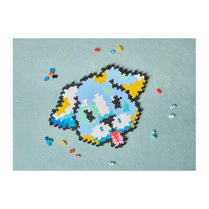 A completed Plus-Plus Puzzle By Number Puppy model, built from 500 colorful interlocking pieces, with a few pieces scattered.