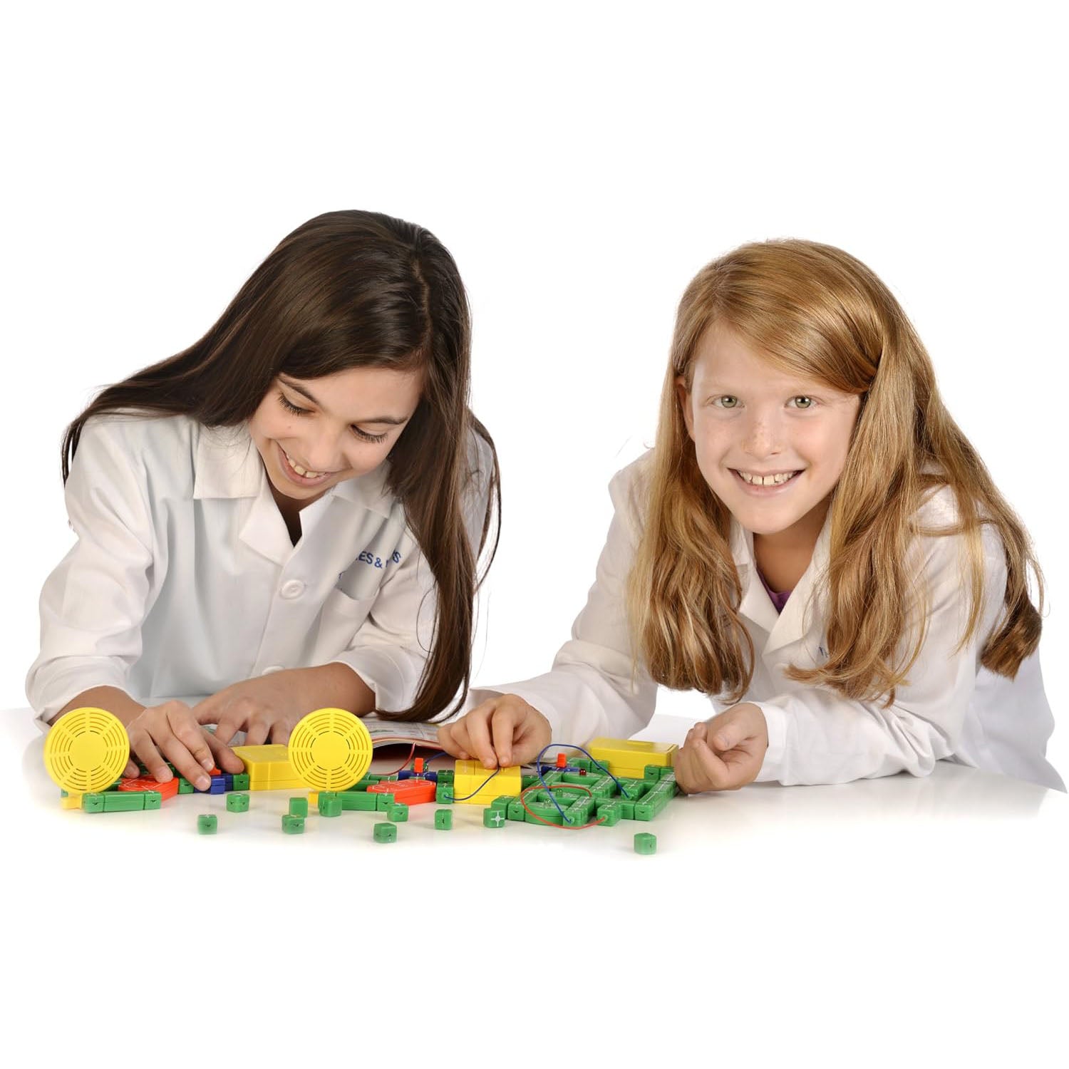 Two girls working together to build an electrical circuit using colorful snap-together components from the Thames & Kosmos Electricity & Magnetism kit.